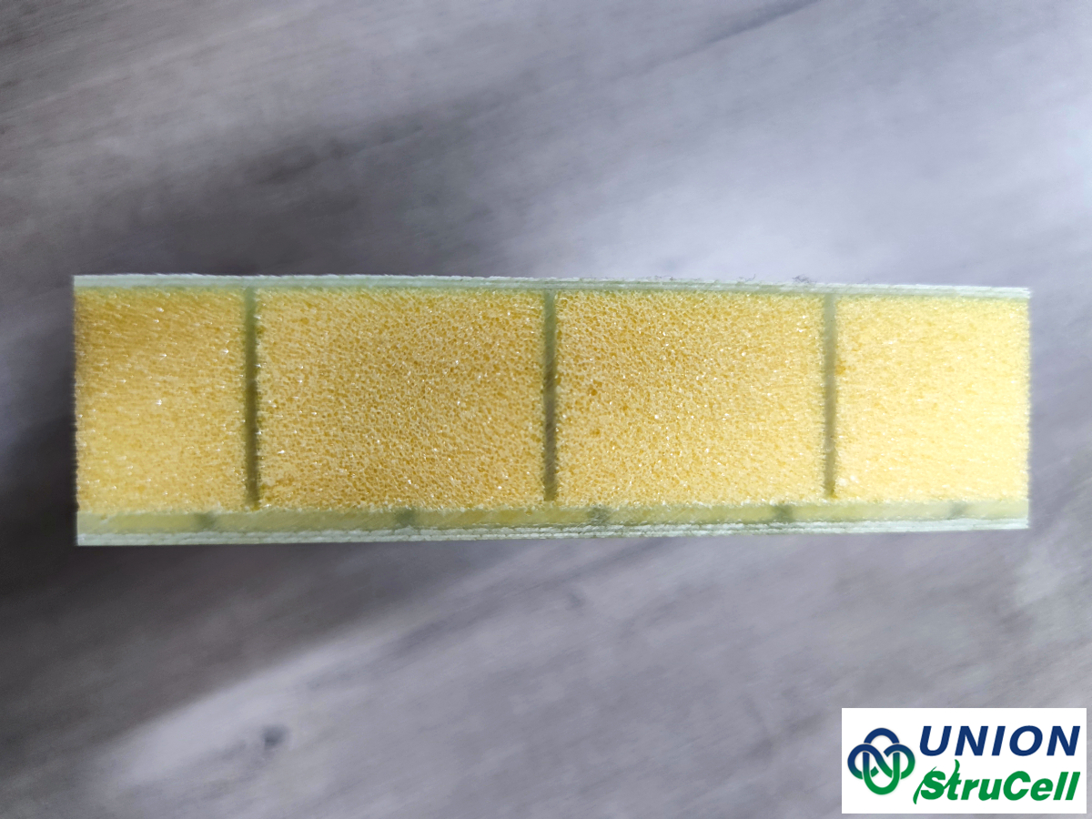 Dettaglio della sezione trasversale che mostra l'anima in schiuma strutturale incollata tra i rivestimenti in fibra di vetro per creare un pannello composito durevole.